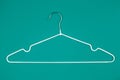 White clothes hanger on turquoise background. Top view Shopping, sale, promo, new season concept