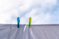 White clothes hung out to dry on a washing line and fastened by the clothes pegs against the blue sky in the bright warm sunny day Royalty Free Stock Photo