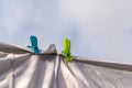 White clothes hung out to dry on a washing line and fastened by the clothes pegs against the blue sky in the bright warm sunny day Royalty Free Stock Photo