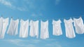 White clothes on a laundry line, against blue sky with light clouds. Generative AI