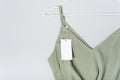 White clothing tag, label blank mockup, to place your design. Cotton khaki green blouse, hanger