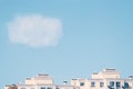 White cloud above the roof of a multi-storey building