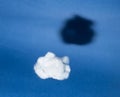 White cloud with black shadow on blue sky background. Comparison, reverse side of medal concept. Surrealism style