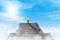 Businessman standing on the top of concrete staircase and looking forward to sky.