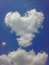 White cloud on a blue sky in the shape of a heart on a blue background close-up. Royalty Free Stock Photo