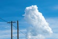 White cloud at the sky, over the old wooden electricity post and wires Royalty Free Stock Photo