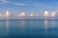 White clouds above tranquil ocean water