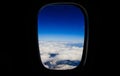 White clouds background hanging on blue sky and covers snowy mountain. Aerial photo from plane`s window. Black background