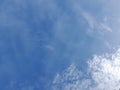 White clouds in the blue sky. Beautiful bright blue background. Light cloudy, good weather. Curly clouds on a sunny day. Royalty Free Stock Photo