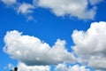 White clouds on a blue sky float at noon. Beautiful atmospheric phenomenon. Natural horizontal background Royalty Free Stock Photo