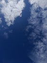 White clouds in the blue sky. Heaven and infinity. Beautiful bright blue background. Light cloudy, good weather. Royalty Free Stock Photo