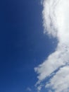 White clouds in the blue sky. Heaven and infinity. Beautiful bright blue background. Light cloudy, good weather. Royalty Free Stock Photo