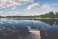 White clouds on the blue sky over blue lake with boats and board Royalty Free Stock Photo