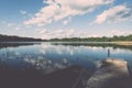 White clouds on the blue sky over blue lake with boats and board Royalty Free Stock Photo