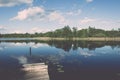 White clouds on the blue sky over blue lake with boats and board Royalty Free Stock Photo