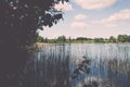 White clouds on the blue sky over blue lake - retro vintage effect Royalty Free Stock Photo