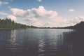 White clouds on the blue sky over blue lake - retro vintage effect Royalty Free Stock Photo