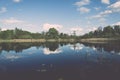 White clouds on the blue sky over blue lake - retro vintage effect Royalty Free Stock Photo