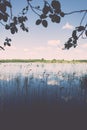 White clouds on the blue sky over blue lake - retro vintage effect Royalty Free Stock Photo