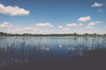 White clouds on the blue sky over blue lake - retro vintage effect Royalty Free Stock Photo