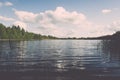 White clouds on the blue sky over blue lake - retro vintage effect Royalty Free Stock Photo