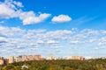 White clouds in blue sky over houses and park Royalty Free Stock Photo