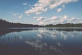 White clouds on the blue sky over blue lake - retro vintage effect Royalty Free Stock Photo