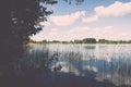 White clouds on the blue sky over blue lake - retro vintage effect Royalty Free Stock Photo