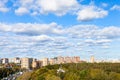 White clouds in blue sky over street and park Royalty Free Stock Photo