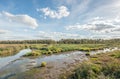 White clouds and blue sky reflecting in the mirror smooth surface of a swampy creek Royalty Free Stock Photo