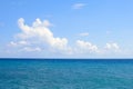 White clouds on a blue sky and sea. Sunny day on the Aegean. Calmness and harmony. The horizon between the sky and the sea. Greece