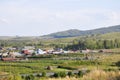 White clouds in the bright blue summer sky over village with small houses far away in the mountains and fields. Travelling. Peopl Royalty Free Stock Photo