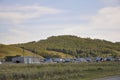 White clouds in the bright blue summer sky over village with small houses far away in the mountains and fields. Travelling. Peopl Royalty Free Stock Photo