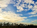 White clouds sky evening golden light sun shining through Royalty Free Stock Photo