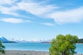 White clouds drit through blue sky above Lake Tekapo