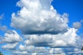 White clouds float across the blue sky at noon. Beautiful atmospheric phenomenon. Natural horizontal background Royalty Free Stock Photo