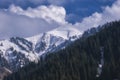 White clouds, float beautifully over snow covered mountain peak, a beautiful mountain landscape, Peak Katyrbulak in Almaty Royalty Free Stock Photo