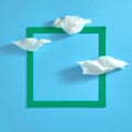 White clouds and a green square frame on a light blue background. Template. Text space. Top view. Flat lay Royalty Free Stock Photo