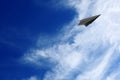 White clouds and paper airplane flying in blue sky on sunny day. Space for text Royalty Free Stock Photo