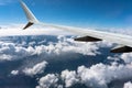 White clouds sail under the wing of an airplane Royalty Free Stock Photo