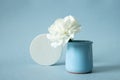 White cocncrete circle shaped pedestal and white flower in vase on blue pastel paper background. Stone platform Royalty Free Stock Photo