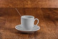 White coffe Cup with spoon on white saucer on dark brown wooden background Royalty Free Stock Photo