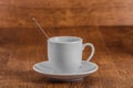 White coffe Cup with spoon on white saucer on dark brown wooden background Royalty Free Stock Photo