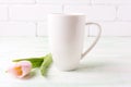 White coffee cappuccino mug mockup with pink tulip Royalty Free Stock Photo