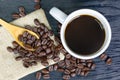 White coffee cup with coffee beans on a wood grain background Royalty Free Stock Photo