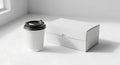 White Coffee Cup and Box on a Clean White Surface Royalty Free Stock Photo