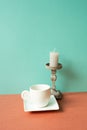 White coffee cup with candle on red table. mint green wall background Royalty Free Stock Photo