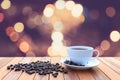 White coffee cup and coffee beans on wood table with blurred bac Royalty Free Stock Photo