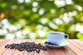 White coffee cup and coffee beans on wood table with blurred bac Royalty Free Stock Photo