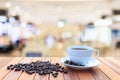 White coffee cup and coffee beans on wood table with blurred bac Royalty Free Stock Photo